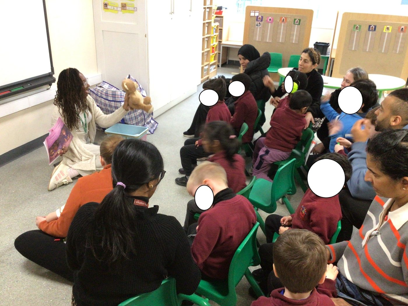 Talia reading one of her picture books to a class of primary school children and their parents